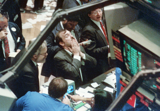 史上最大の下落幅を記録したニューヨーク証券取引所でぼうぜんとするディーラー【1987年10月撮影】